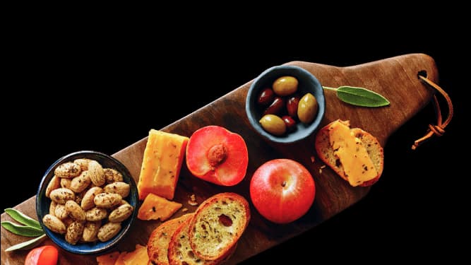 A gourmet charcuterie board spread featuring Garlic, Herb & Olive Oil almonds.